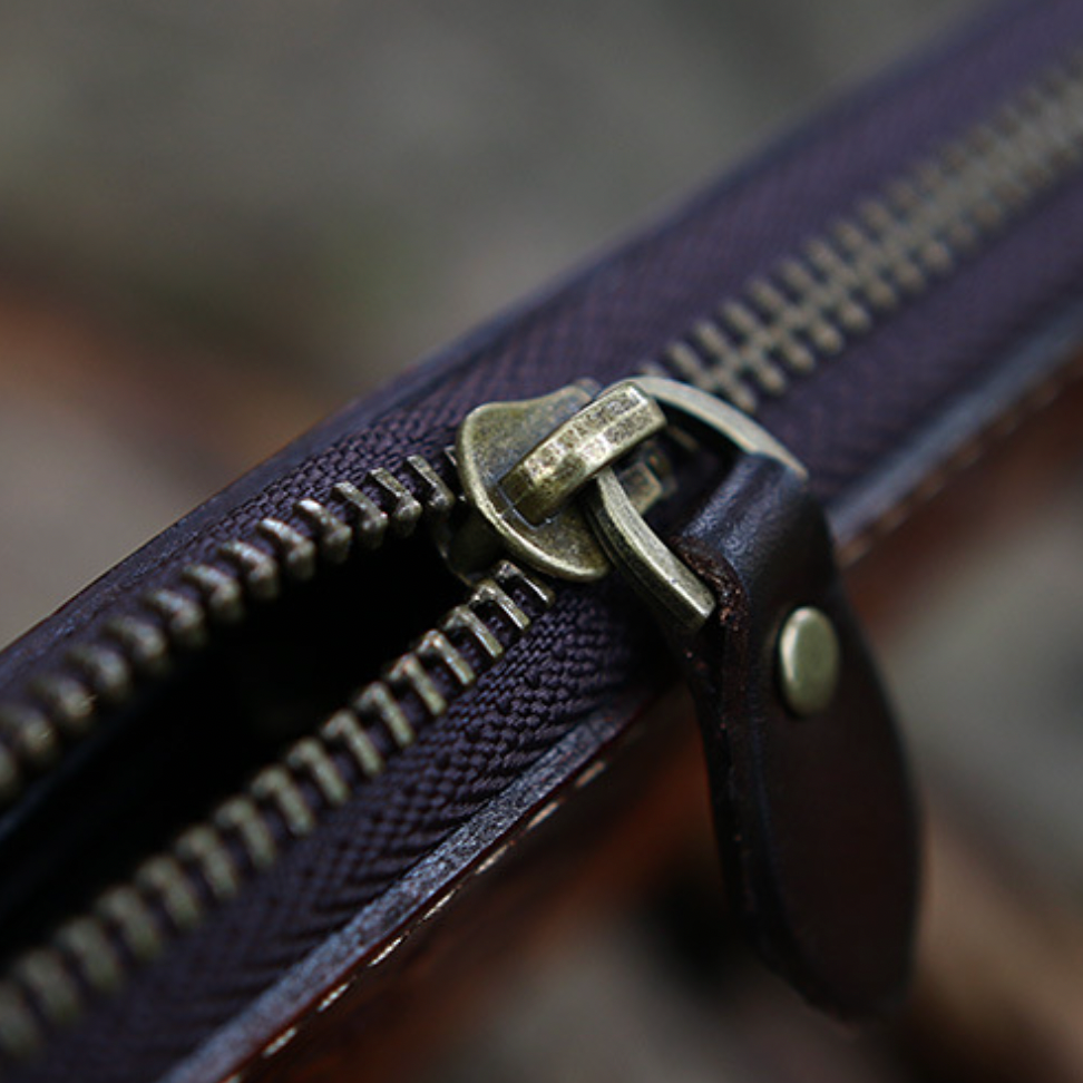 Close-up of a zipper on a leather bag with a blurred background