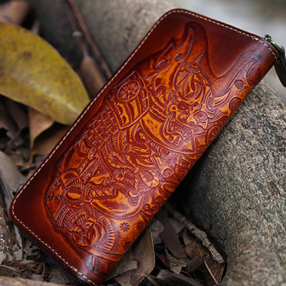 Brown leather wallet with intricate designs on a stone surface